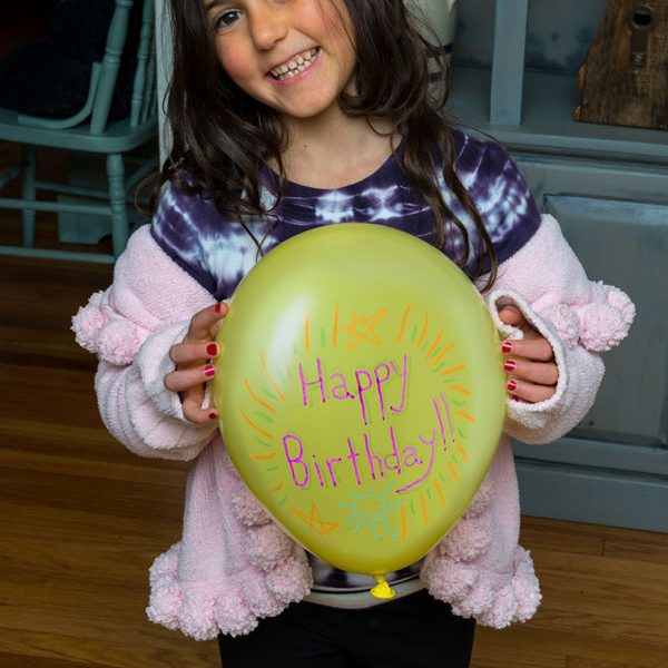 child holding yellow balloon with 
