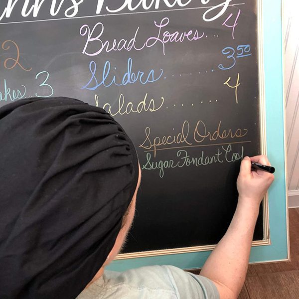 man writing on chalkboard menu glam photo